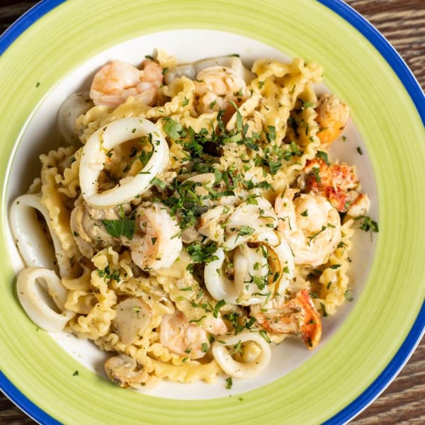 Fanny's seafood pasta with shrimp, calamari, and lobster in a creamy sauce, garnished with parsley.